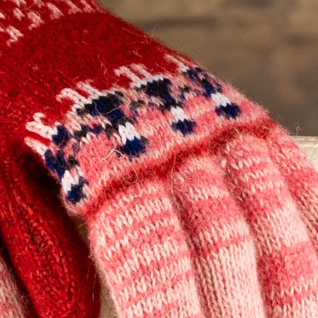 Prachtige warme wollen handschoenen in roze en rood, met mooi poppetjes motief in donker paars en wit. Warme handschoenen voor liefhebbers van kleuren. Deze handschoenen zijn gebreid van zuivere schapenwol. Als jij je handen echt wilt verwennen, dan kun je dat doen moet deze warme handschoenen. Je voelt het ambacht en de kwaliteit, wanneer je ze in handen hebt! Deze handschoenen zijn puur natuur. Schapenwol is ademend en heeft van nature een isolerende werking. Leuk cadeautje voor verjaardag of feestdagen!